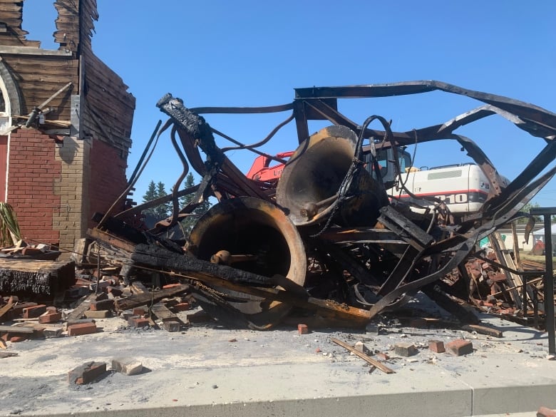 Large church bells surrounded by charred debris.