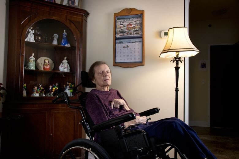 A woman in a wheelchair in front of a calendar.