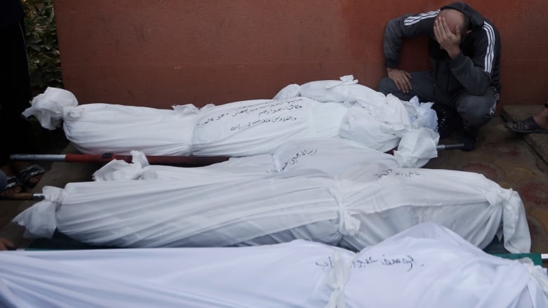 Palestinians mourn relatives killed in the Israeli bombardment of the Gaza Strip outside a morgue in Khan Younis on Sunday, Dec. 10, 2023. 