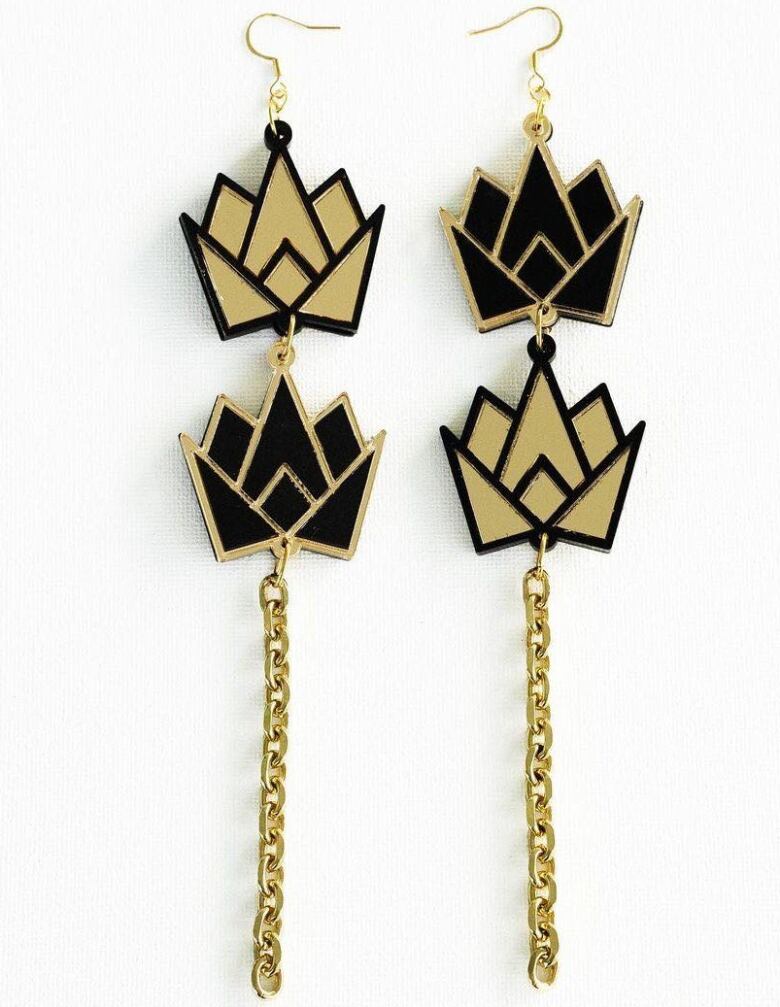 A pair of gold and black earrings, incorporating geometric shapes.