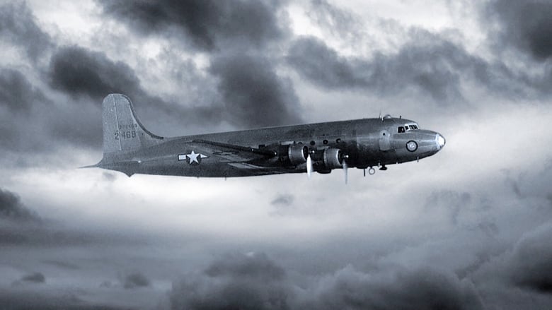 A black and white photo of a Skymaster plane flying in front of clouds. 