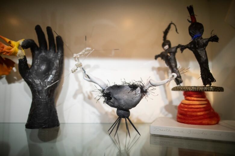 Three mixed media sculptures are displayed on a shelf in Susanna Blunt's home.