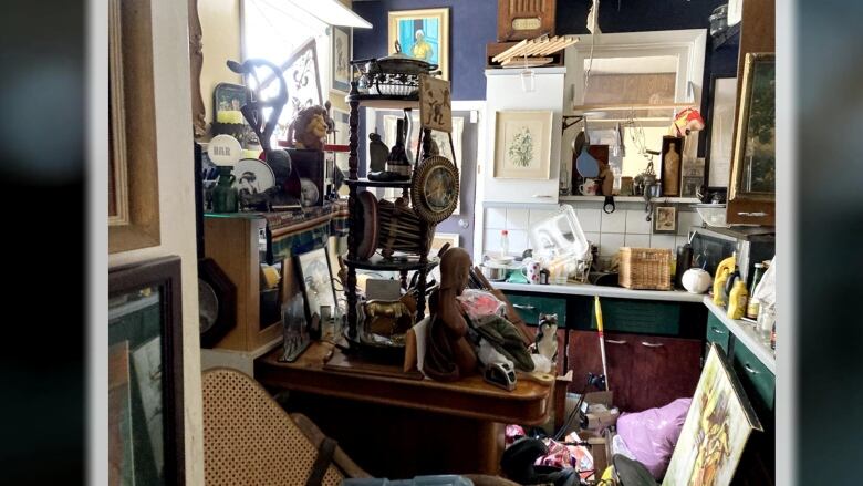 A photo of a very messy kitchen with a lot of knick-knacks and collectables. 