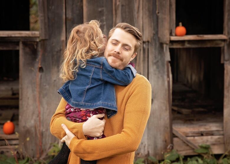 A father holds his daughter. 