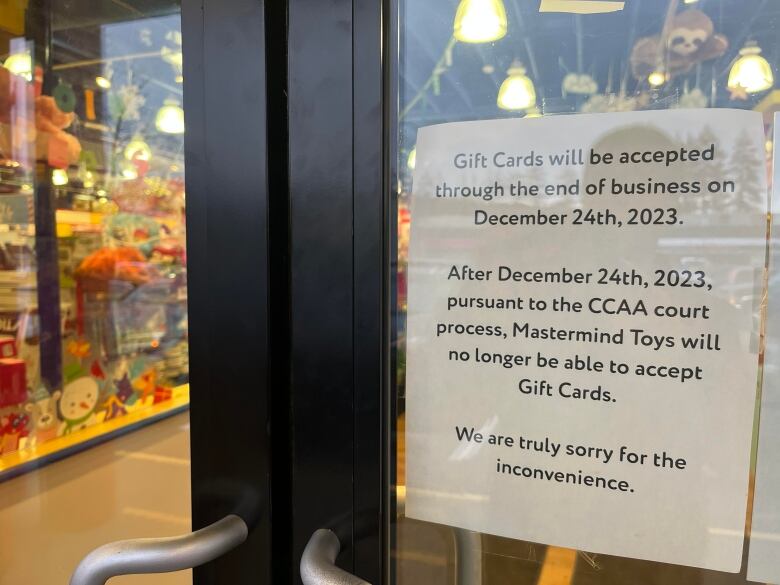 A basic piece of white printer paper is taped to a door notifying people that gift cards will not work after Dec. 24.