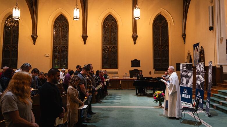 Father Michael Bechard of Ark Aid Street Mission leads a prayer during a service at First-St. Andrew's United Church in London, Ont. to remember those lost to homelessness, Dec. 20, 2023.