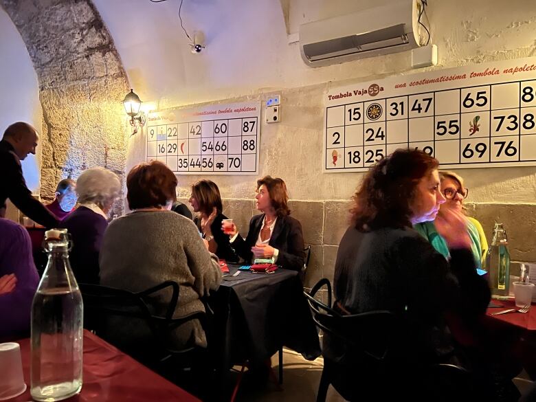 Groups of women sitting around tables in a cavernous bar. 