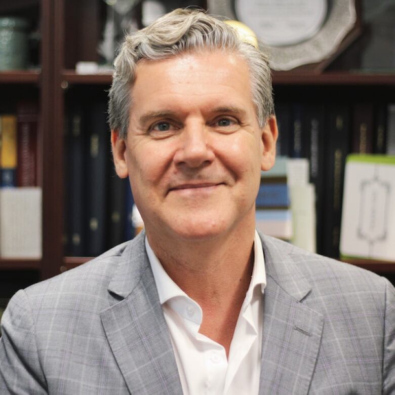 Man in a grey suit jacket and white shirt.