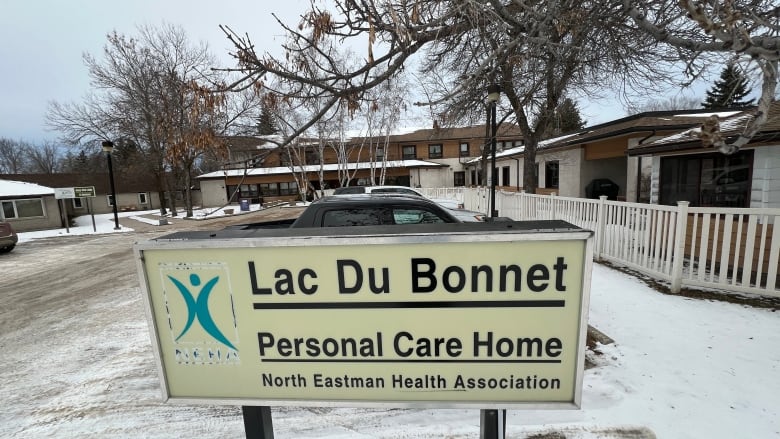 An old sign says Lac du Bonnet personal care home in front a two-storey residential housing complex.