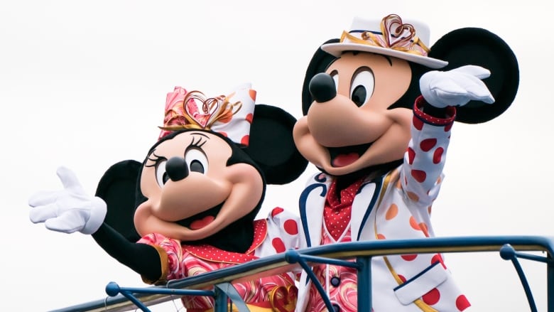 Mickey and Minnie mouse wave to the crowd.