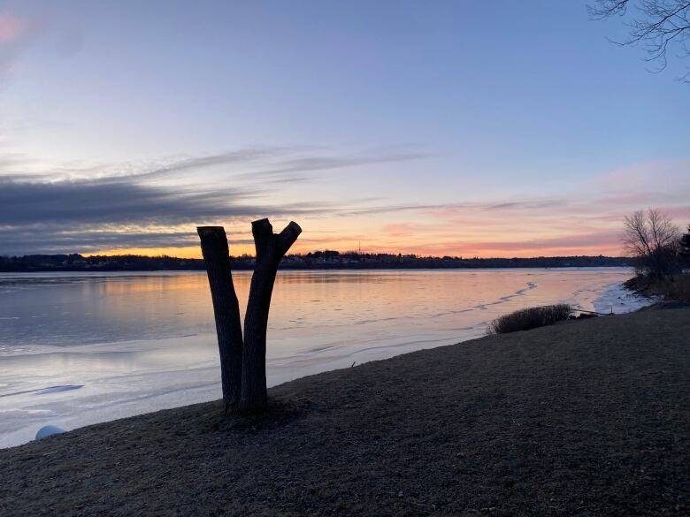 A sunrise over a slightly frozen lake.