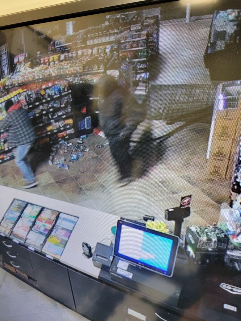 In the screen shot of security footage two people can be seen in the store