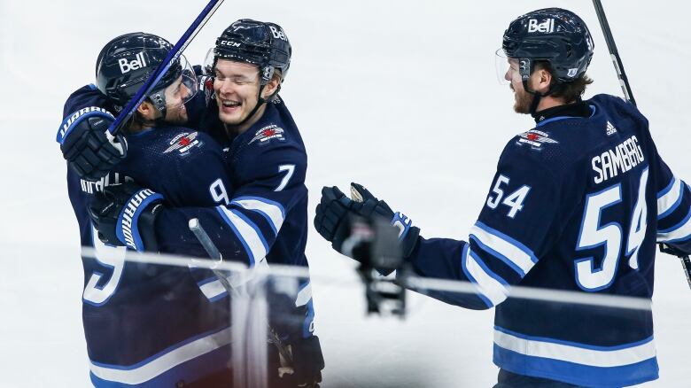 Hockey players celebrate together following a goal.