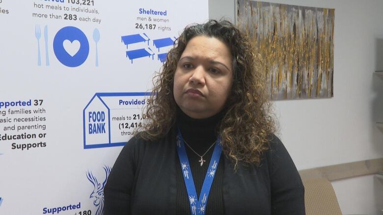 A woman stands in front of a board.