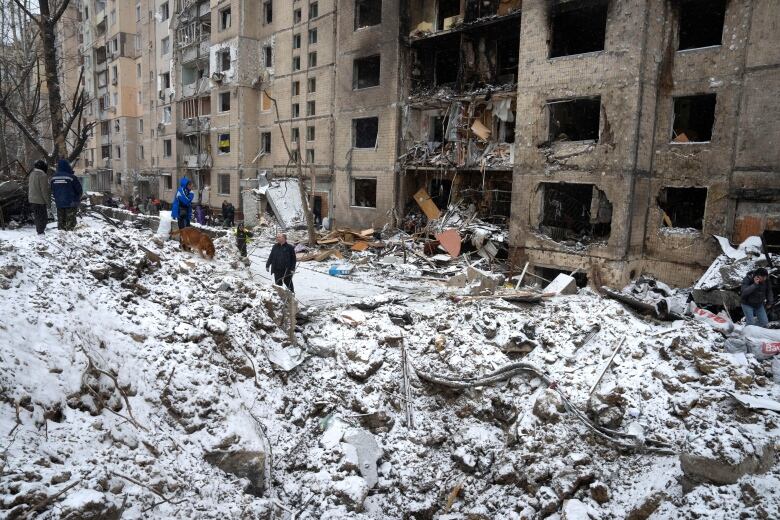 A crater of an explosion is next to an apartment building.