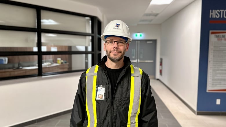 A portrait of a person in a safety vest and hard hat. 