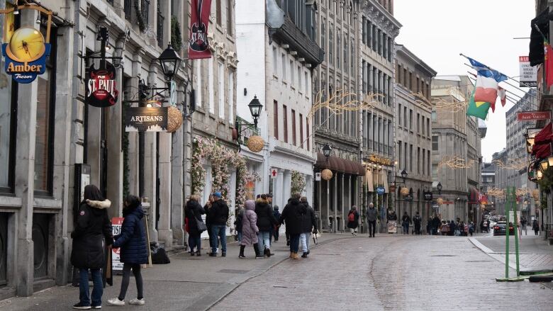 People walk on the snowless streets in Old Montreal, Wednesday, Jan. 3, 2024. 