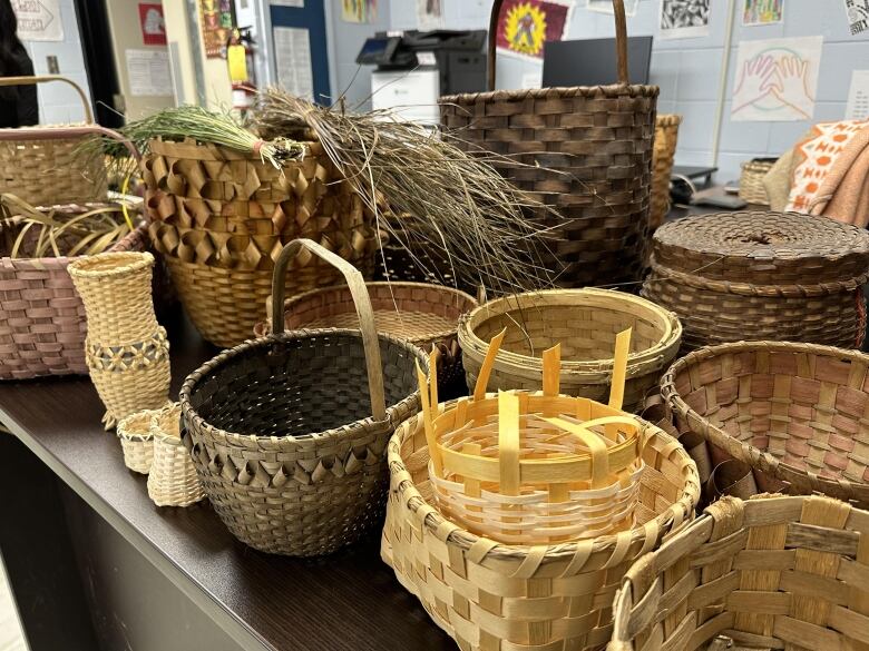 A table laden with baskets in various sizes and shades of brown.