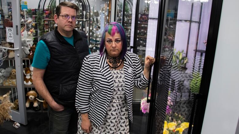 A man and woman stand in a flower shop.