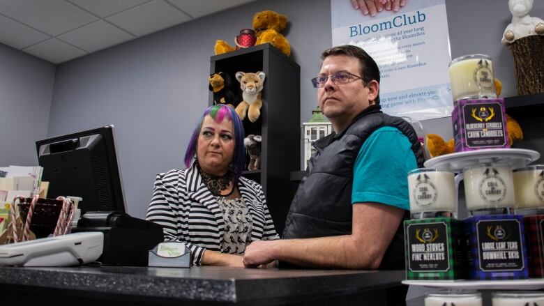 A man and woman stand in a flower shop.