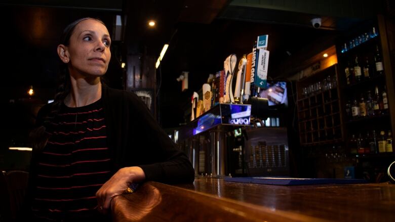 A woman sits at a bar.