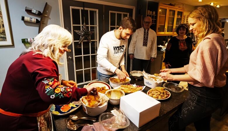 People gather around bowls of food.