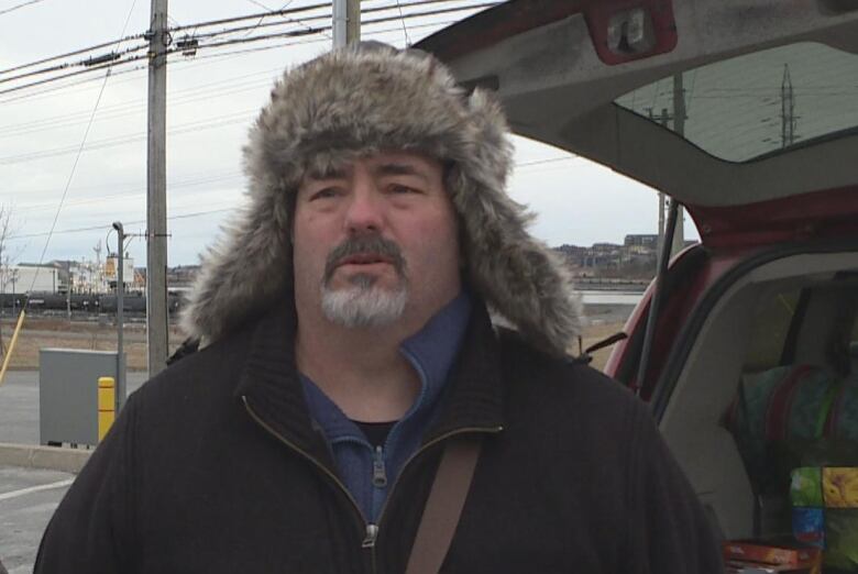 A man with a fluffy hat on and black jacket.