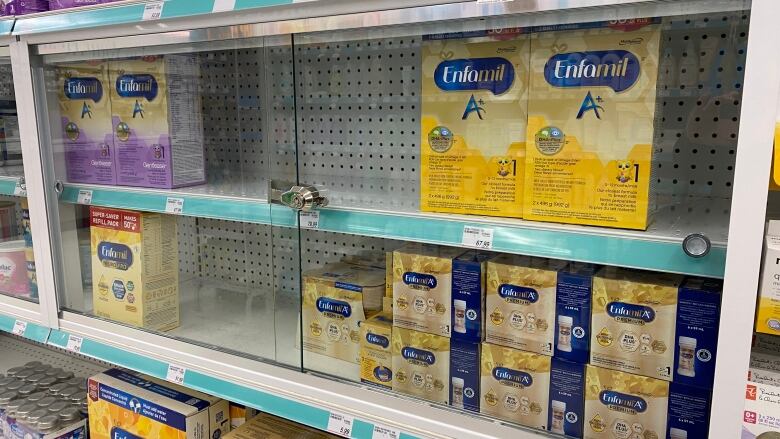 baby formula on a shelf behind glass.