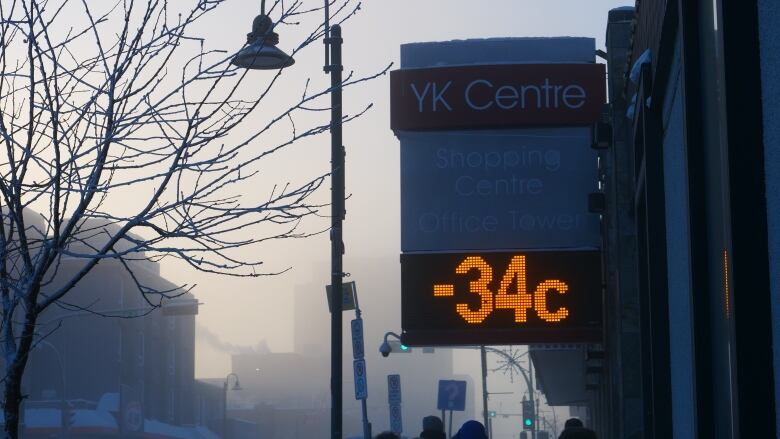 Temperature sign with cold weather around.