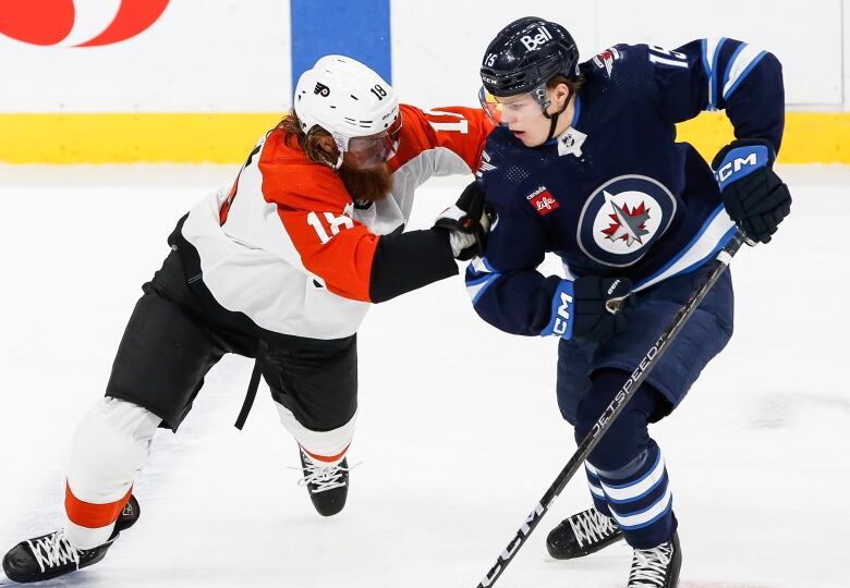 Two hockey players battle for positioning.