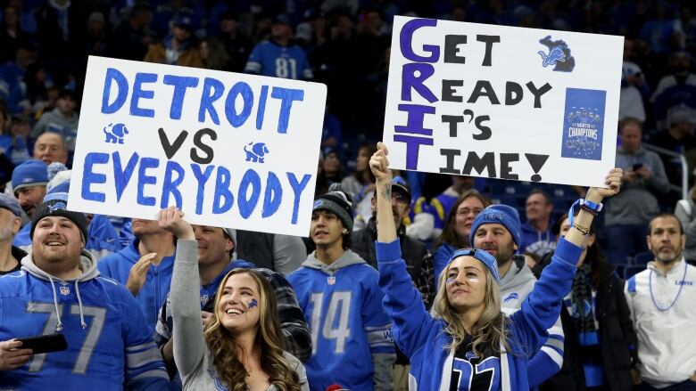 Fans hold signs