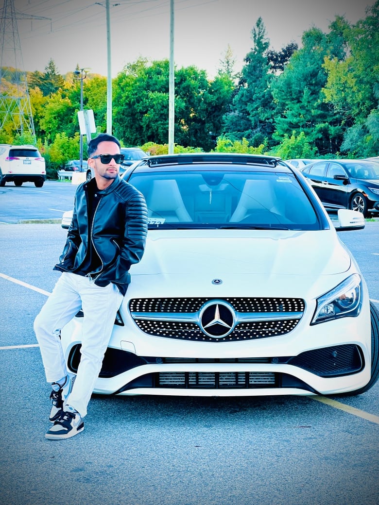 Man in sunglasses leans on white mercedes benz