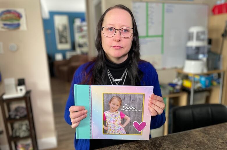 Christina Hecktus holds a photo of her daughter Quin. 