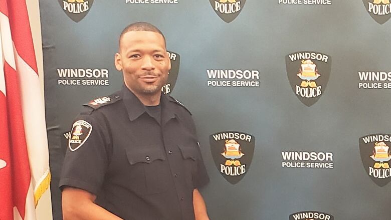 A police officer poses with his badge.