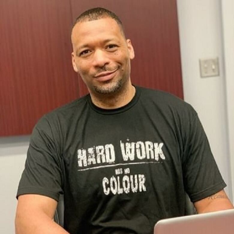 A man sits and smiles for the camera.