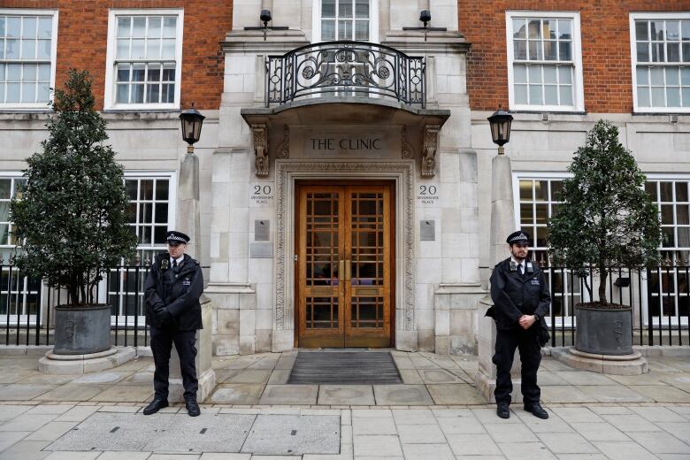 Two police officers stand outside a private hospital in London, England.