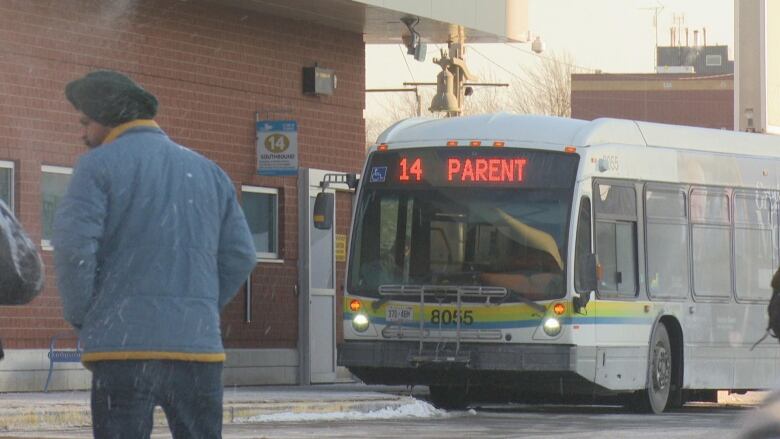 A person walks by a bus on a cold day in Windsor. 