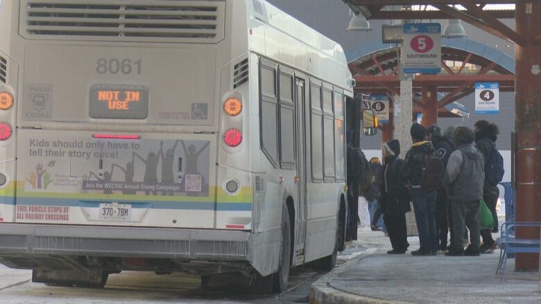 People board a bus at the downtown Windsor bus terminal on a frigid winter day.