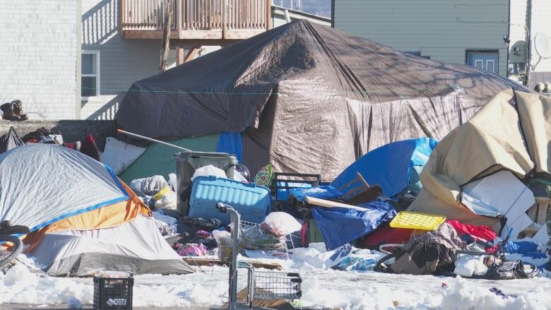 A tent encampment surrounded by a variety of possessions. 