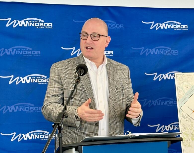 Dilkens speaking at a podium.