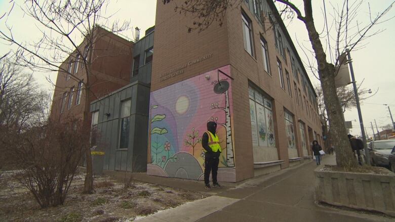 Security stands in front of building.