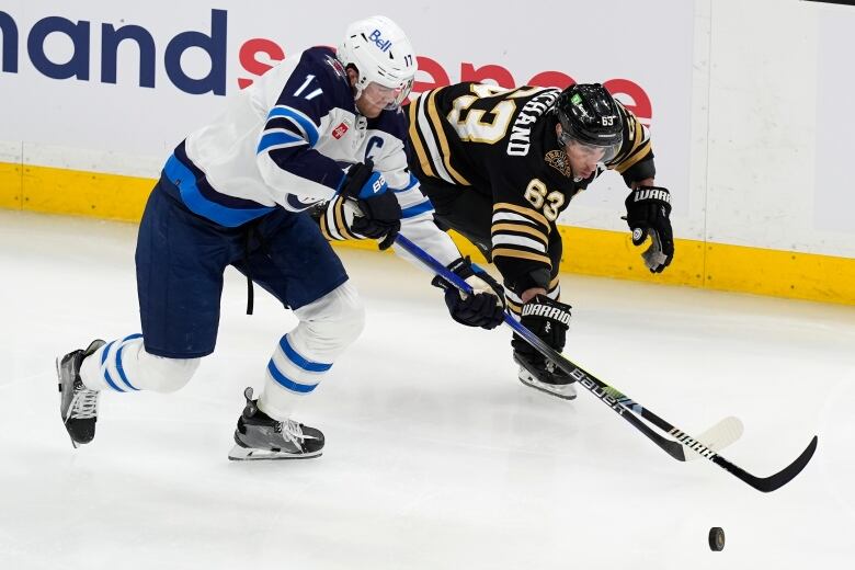 Two hockey players battle for the puck.