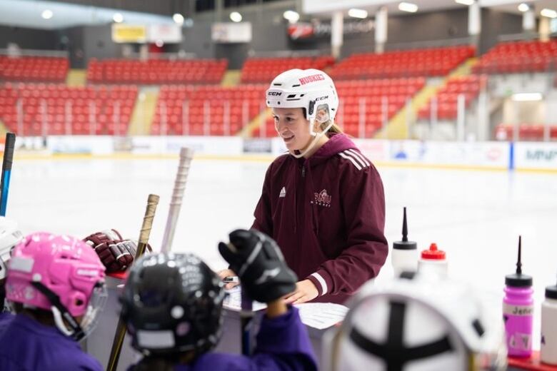 A Mi'kmaw woman coaching youth hockey players 