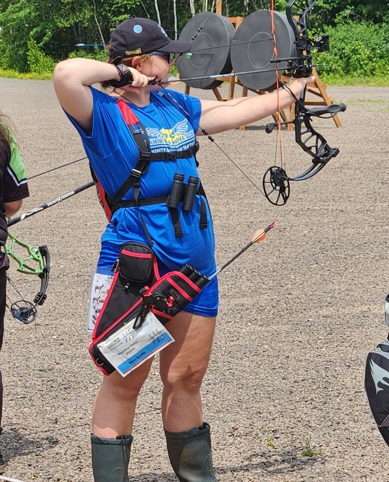 A Mi'kmaw woman with a bow and a team Mi'kma'ki jersey