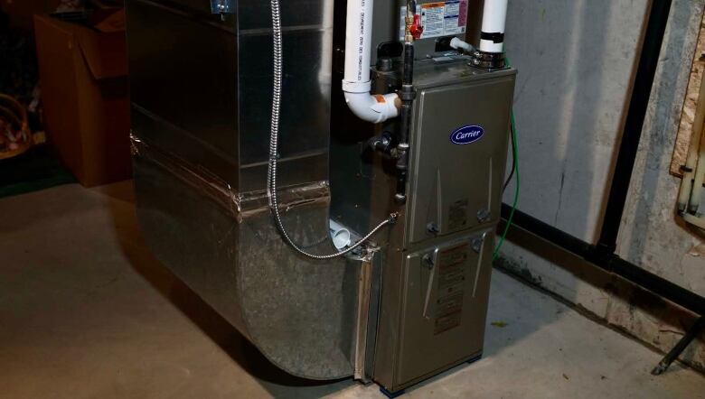 A furnace unit is seen in a basement setting. 