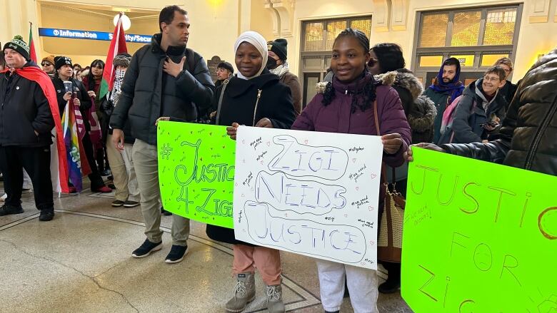 People hold up signs of support.