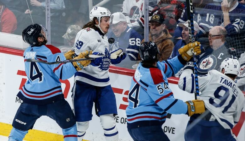 Hockey players battle for the puck.