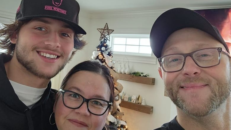 A man and a woman take a selfie with their son.