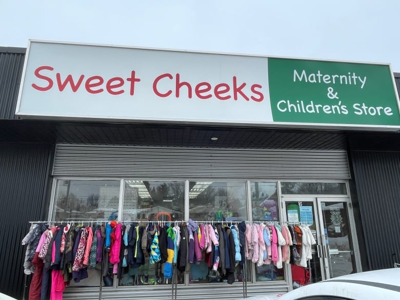 A storefront with a sign that says Sweet Cheeks Maternity and Children's Store.