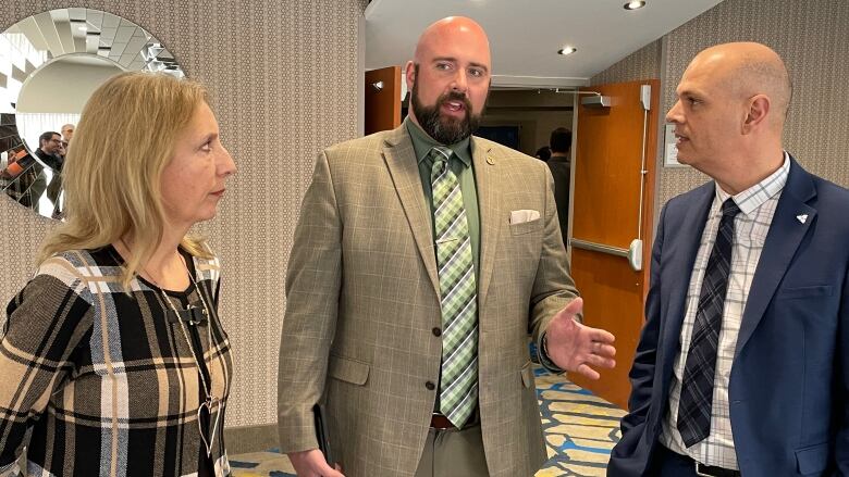 Three people standing in a hotel lobby.